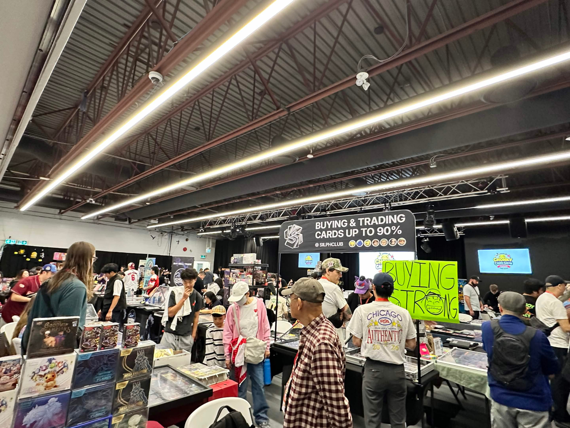 Collectors browsing vendor booths and boxes of trading cards