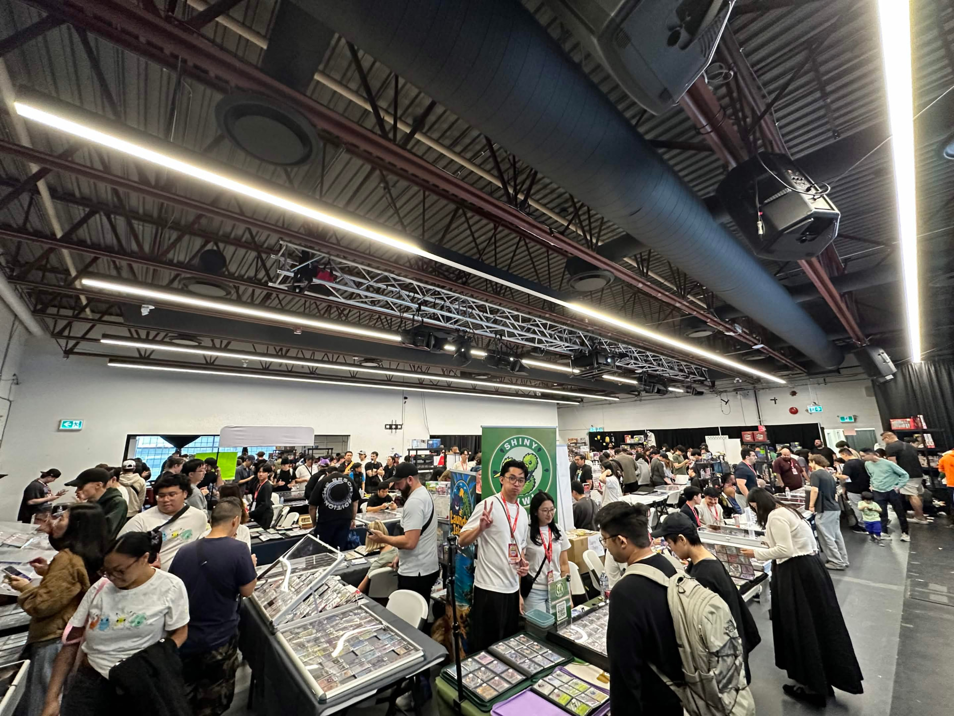 Wide view of the show floor, tables of cards stretching down the aisles